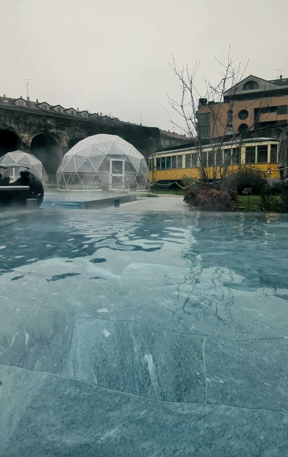 outdoor pool with greenery in the background at qc terme milano spa