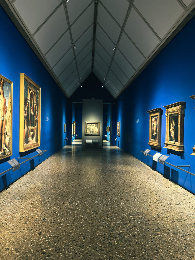 Gallery room with blue walls and classical paintings at Pinacoteca di Brera in Milan